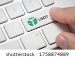 Crypto Currency Finance Concept:Finger pressing computer key with tether coin logo.Crypto usdt concept.