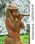 Small photo of IQUITOS, PERU - APRIL 25, 2012 : An Indian tribesman from the Yagua village located on the Amazon River near Iquitos in Peru demonstrates the use of a pucuna or blowpipe.