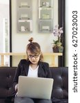 Small photo of Asian female accountant or banker is busy working with laptop, smart phone and document in home office in selective focus. Concept : Busywork