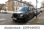 Small photo of Black Cab Electric vehicle charging at public charging station in London - January,2023. New energy vehicles, eco-friendly alternative energy for cars. Electric cars used as taxis and hackney carriage