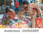 Small photo of Mahesh, 06-28-2023: a seller couple selling multicolour satin made decoration (to be used as ornamental mattress for Lord Jagannath) at Gundicha Bari temple on the occasion of Ulta Rath festival.