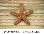 One Starfish Lies On A Mat On...