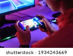 Gamer playing online game on smart phone in dark room. e-Sport Games compilation and Internet Championship.