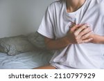 Small photo of Woman holding chest because of heart disease, heart attack, heart pain or chest pain