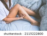 Woman lying in the bed and suffering from leg muscle cramps. Muscle pain or leg pain while sleeping