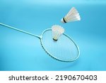 Badminton shuttlecock and badminton racket on blue background