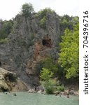 Small photo of DAVIS, OKLAHOMA—Families enjoy a day swimming at the Turner Falls with a view of the cave at the rocky wall above the pool in September 2015. Turner Falls, Arbuckle Mountains, Oklahoma