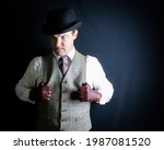 Small photo of Portrait of Dangerous Man in Bowler Hat on Black Background. Old-Fashioned Ruffian or Rogue. Uncouth Criminal and Unmitigated Cad
