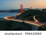 Golden Gate Bridge and light trail of Highway 1 during sunset