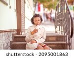 Small photo of Young African American woman eating pink ice cream in a crispy waffle cone, lifestyle, city walk, theism.