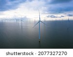 Aerial view of enormous windmills stand in the sea along a dutch sea. Fryslân wind farm, the largest inland wind farm in the world. Friesland, Afsluitdiijk, Ijsselmeer, Breezanddijk, Netherlands