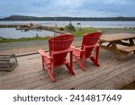 Small photo of Terra Nova National Park, Newfoundland, Canada -Jul 8, 2023: Parks Canada red chairs overlooking Newman Sound in Terra Nova National Park. Boat launching and mooring.
