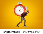Side view of young handsome man carrying huge alarm clock on his back on yellow gradient background. Meet deadlines. Live in hectic world. Adjust to overbusy schedule.