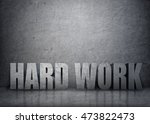 Small photo of Big 3d concrete words 'hard work' in stone interior. Profit and success. Backbreaking work. Sweated labour.
