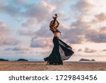 beautiful young tribal style woman on the beach at sunset