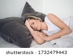 Small photo of Depressed woman tormented by restless sleep, she is exhausted and suffering from insomnia, bad dreams or nightmares, psychological problems. Inconvenient uncomfortable bed or mattress. Lack of sleep