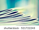 Close up edge of colorful magazine stacking with  blurry bookshelf background for publication and publishing concept , extremely shallow DOF with vintage retro color tone