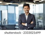 Small photo of Portrait of successful mature boss, senior businessman in business suit looking at camera and smiling, man with crossed arms working inside modern office building