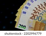 European cash. 200 euro bills on a black background.