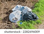 Illegal dumping with plastic bags abandoned in nature