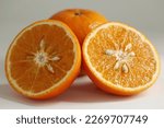 Small photo of close up photo slice orange, orange slice put on flor and inside has seed of orange, haft orange slice put on floor
