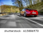 Generic red sports car driving fast on the open road