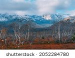 Small photo of Autumn arctic landscape. View of the misty snow-capped mountains and autumn colorful tundra in the Arctic,Kola Peninsula. Mountain hikes and adventures. Austere, cold atmosphere.