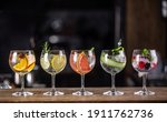 Small photo of Gin tonic long drink as a classic cocktail in various forms with garnish in individual glasses such as orange, lemon, grapefruit, cucumber or berries.