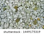 Small photo of ballast rock made of crushed lumpish limestone for railway track by close-up view with light white grey texture and inserted rusty yellow brown stones on background