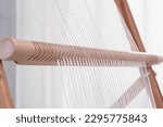 Small photo of Shaft on a weaving frame. Shaft and warp thread on a weaving tool. The process of making tapestry and carpets. Culture and ancient tradition of making cloth by hand. Manual labor