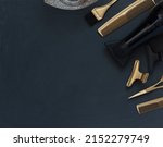 Small photo of Hairdressing tools in black and gold on gray concrete background. Hair salon accessories, hair dryer, combs, scissors and hair clips in the corner and copy space.