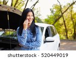 Smiling woman calling someone for help with his broken car