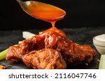 Small photo of Classic buffalo wings topped with sauce. BBQ wings.