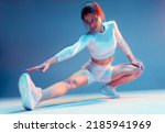 Small photo of Pilates workout. Fit sports girl stretching legs, hips muscles, squatting. Fitness training, wellness. Long exposure