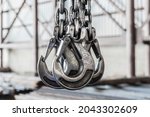 Lifting mechanism iron chain with a hook of an overhead crane on the background of an industrial enterprise or factory