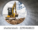 Small photo of Mini excavator at the construction site on the edge of a pit against a cloudy blue sky. Compact construction equipment for earthworks. An indispensable assistant for earthworks