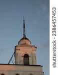 Small photo of The old spire of the monastery against the sunset sky. Restoration of the old spire of the monastery.