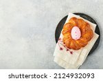 Small photo of Spanish Easter cake. Traditional mona de pascua typical in Spain with boiled eggs eaten inside on light grey background. Typical food of the Spanish pastry Mona de Pascua. Top view. Mock up.
