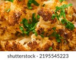 Small photo of Baked cauliflower abstract food background. Oven or whole baked cauliflower spices and herbs server on wooden rustic board on old wooden vintage table background. Eyal Shani dish. Perfect tasty snack