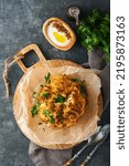 Small photo of Baked cauliflower. Oven or whole baked cauliflower spices and herbs server on wooden rustic board on old gray background table. Delicious cauliflower. Eyal Shani dish. Perfect tasty snack.