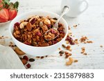 Homemade granola in glass jar with greek yogurt or milk and cashews, almonds, pumpkin with dried cranberry seeds in on white rustic wooden table background. Healthy energy breakfast or snack. Top view