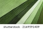 Small photo of samples of fabric for interior upholstery or drapery works in green tone color. swatch of violet zigzag pattern fabric. fabric for luxury interior style. close-up image.