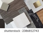 close up view of interior materials sample including black and gery marble stones, wooden vinyl flooring tiles, quartz, ceramic tiles, walnut veneer, terrazzo stone, stainless. mood and tone board.