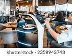Small photo of Robot waiter serve food at modern restaurant table.Offering innovation futuristic high-tech automated dining experience.Bringing,delivery automation order to customer.Digital robotic AI smart service.