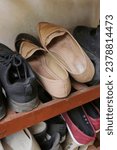Small photo of Close-up of some shoes on a shelf in disorganized condition