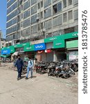 Small photo of People are coming out of the jilani mobile market. There are parked bikes under oppo and vivo signboards - Karachi Pakistan - Sep 2020