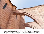 Small photo of External arch in a medieval church in Italy. Flying buttress of the Basilica of Santa Chiara (Saint Clare) in Assisi, Umbria, Italy.