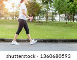 Woman walking in the park with bottle water in summer health care concept.
