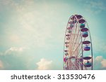 Ferris wheel on cloudy sky background vintage color
