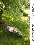 Woman Reading A Book In Garden...